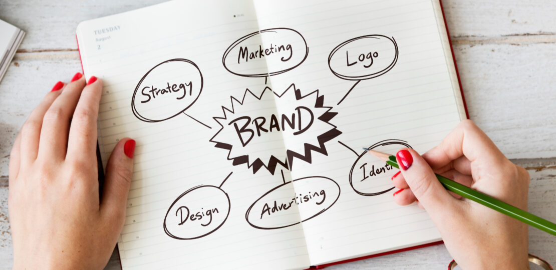 Young woman drawing brand in a notebook